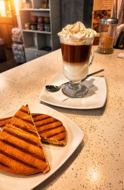 Café con crema y panini tostado en Aromas Caffee