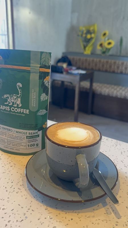 Latte art junto a una bolsa de café en Aromas Caffee Arequipa
